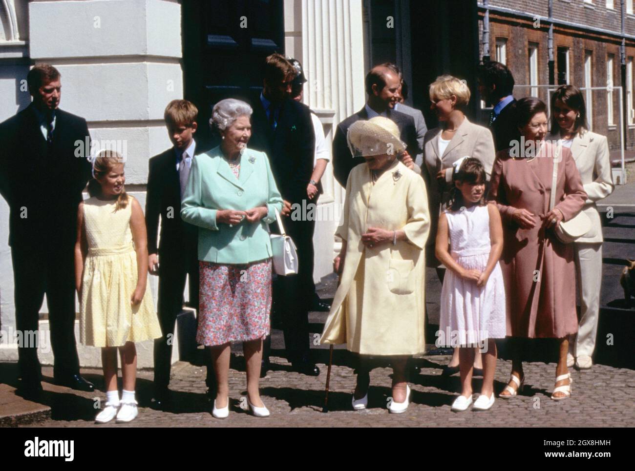Die Königin mit der Queen Mother vor dem Clarence House anlässlich des 98. Geburtstages der Queen Mother. Ebenfalls abgebildet (l-r) Prinz Andrew, Prinzessin Eugenie, Prinz Harry, Prinz William, Prinz Edward, Zara Phillips, Prinzessin Beatrice, Daniel Chatto (hinten), Prinzessin Margaret und Lady Sarah Chatto. Stockfoto