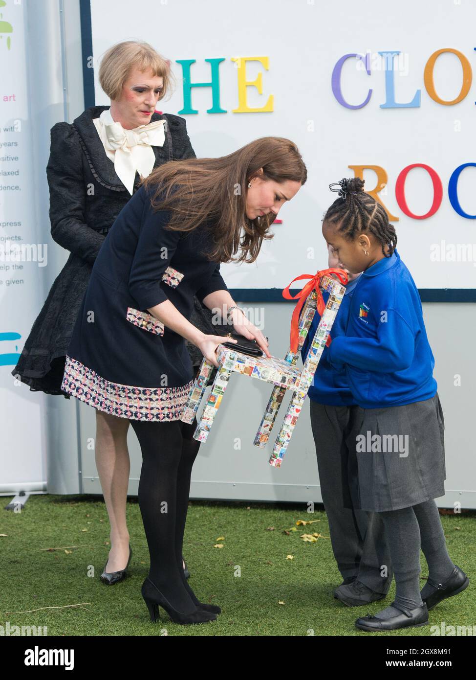 Catherine, Herzogin von Cambridge, trägt ein lockeres, passendes Mutterschaftskleid von Madderson und wird mit einem Pint-großen bedruckten Stuhl präsentiert, möglicherweise ein Geschenk für Prinz William, Während ihres Besuchs an der Barlby Primary School in West London, um am 15. Januar 2015 offiziell den Clore Art Room zu benennen, unterhielt sie sich mit dem mit dem Turner Prize ausgezeichneten Künstler Grayson Perry. Stockfoto