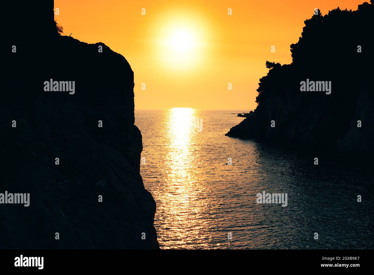 Sonnenuntergang am Meer. Sonne, die aus der Wasseroberfläche reflektiert wird. Wunderschöne goldene Stunde. Stockfoto
