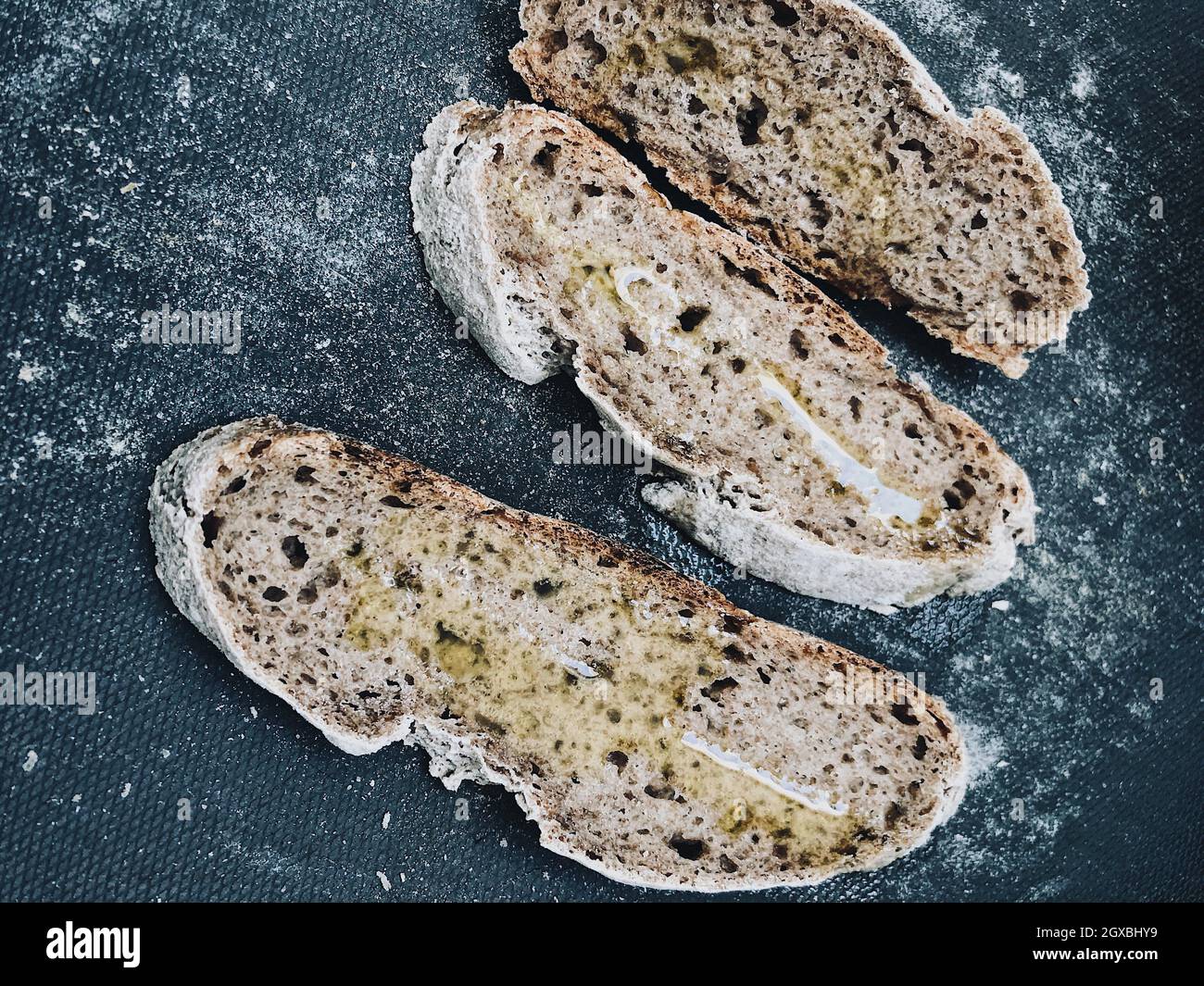 Draufsicht auf drei Scheiben Sauerteig-Brot mit Olivenöl Stockfoto