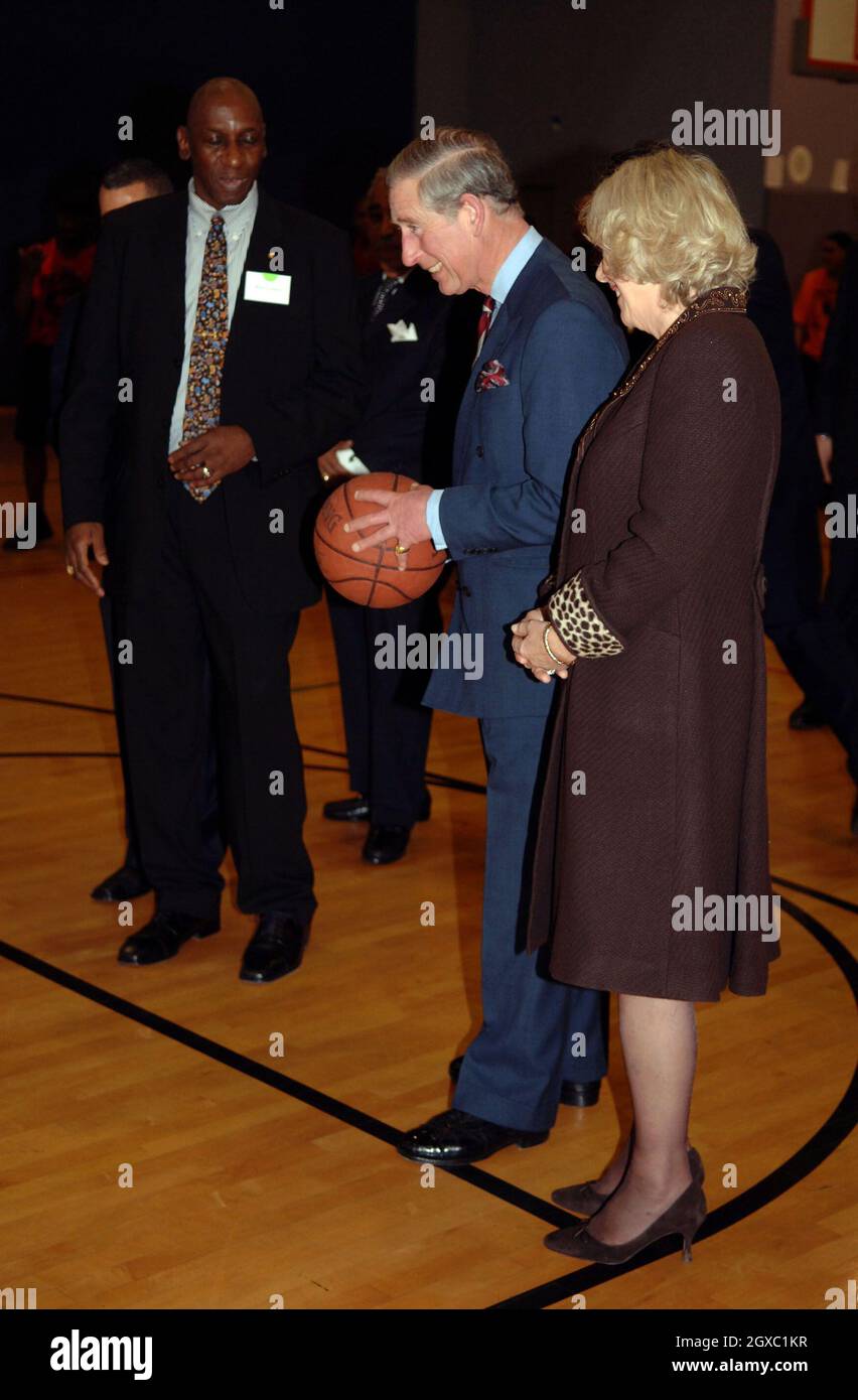 Prinz Charles, Prinz von Wales, bereitet sich auf den Schuss vor, während Camilla, Herzogin von Cornwall, bei Basketballübungen in der Harlem Children's Zone, einem Projekt, das benachteiligten Kindern helfen soll, ihr volles Potenzial auszuschöpfen, am 28. Januar 2007 in New York amüsiert wirkt. Anwar Hussein/EMPICS Entertainment Stockfoto