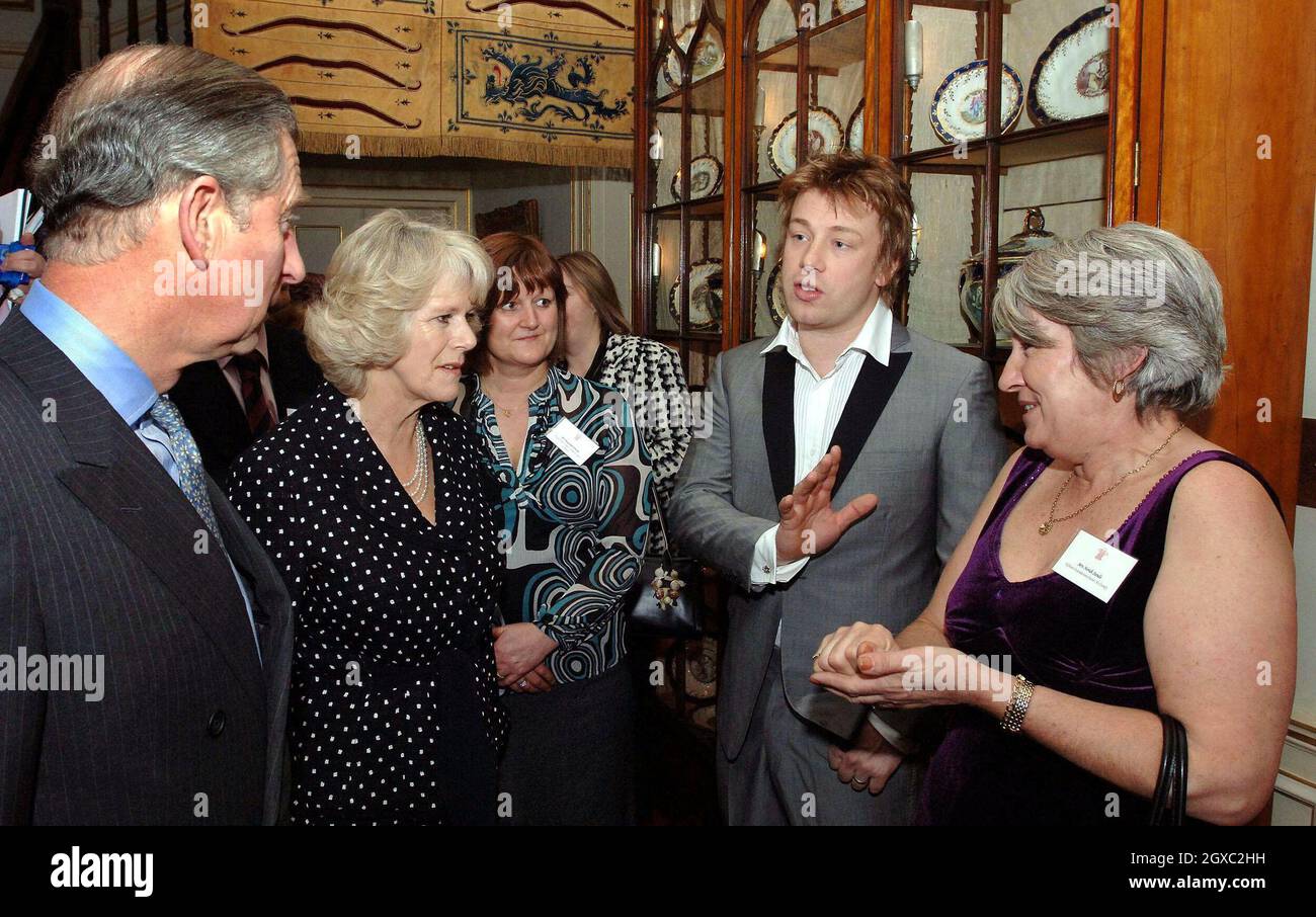 Prinz Charles, Prinz von Wales und Camilla, Herzogin von Cornwall, unterhalten sich mit Fernsehkoch Jamie Oliver und Norah Sands (R) während eines Empfangs für Schulköche im Clarence House in London am 15. Februar 2007. Stockfoto