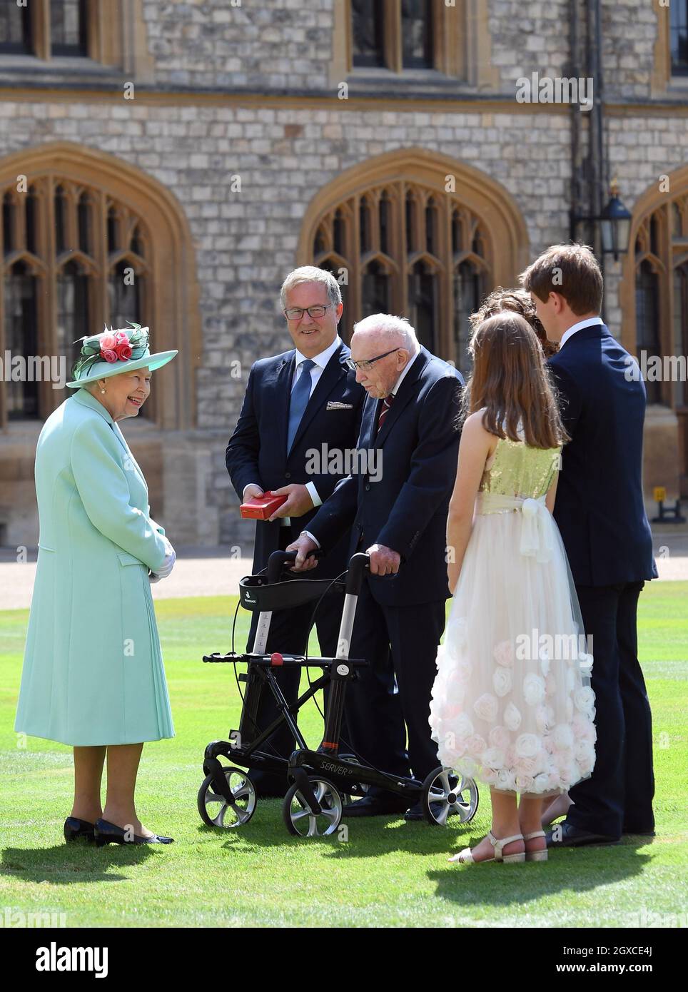 Königin Elizabeth II. (Mit dem Schwert, das ihrem Vater, König George VI., gehörte) verleiht dem 100-jährigen Kapitän Sir Thomas Moore die Ehre der Ritterschaft, bevor er ihm am 17. Juli 2020 bei einer Investiturfeier im Schloss Windsor die Insignien des Knight Bachelor überreicht. Captain Tom Moore hat während der Coronavirus-Pandemie über £32 Millionen für den NHS gesammelt. Stockfoto