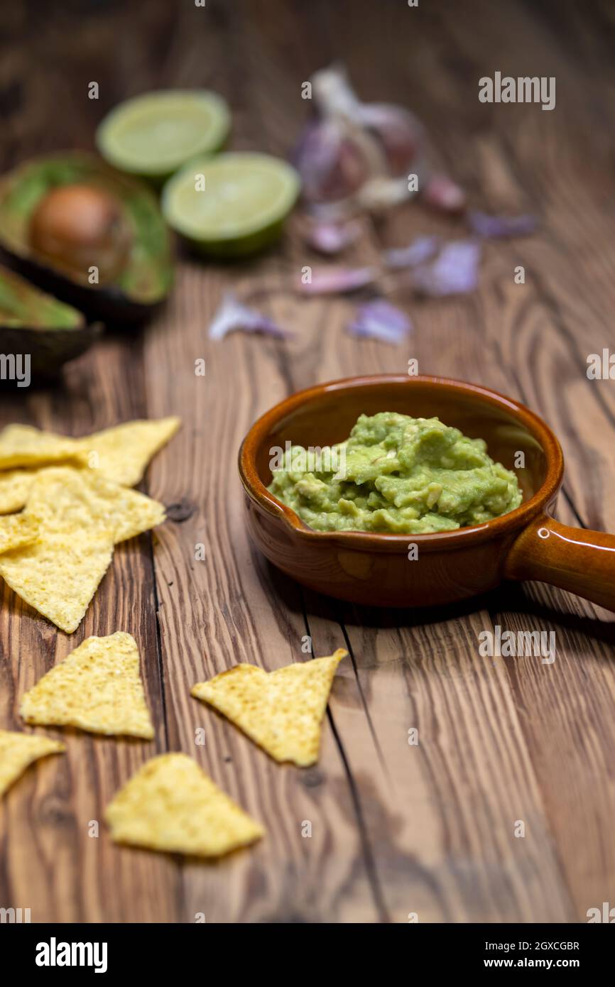 Avocado Dip mit Knoblauch, Chili, Pfeffer und Limettensaft mit Mais Nachos gewürzt Stockfoto