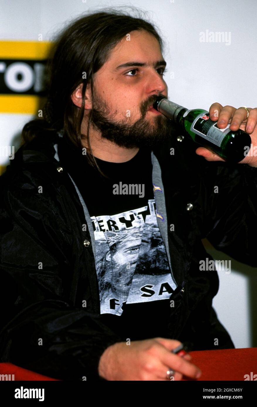 Der brasilianische Heavy Metal-Gitarrist Andreas Kisser von Sepultura trinkt Bier während einer CD-Unterzeichnung im Londoner Virgin Megastore, wo sie für die Veröffentlichung ihres sechsten Albums 'Roots' werben. Stockfoto