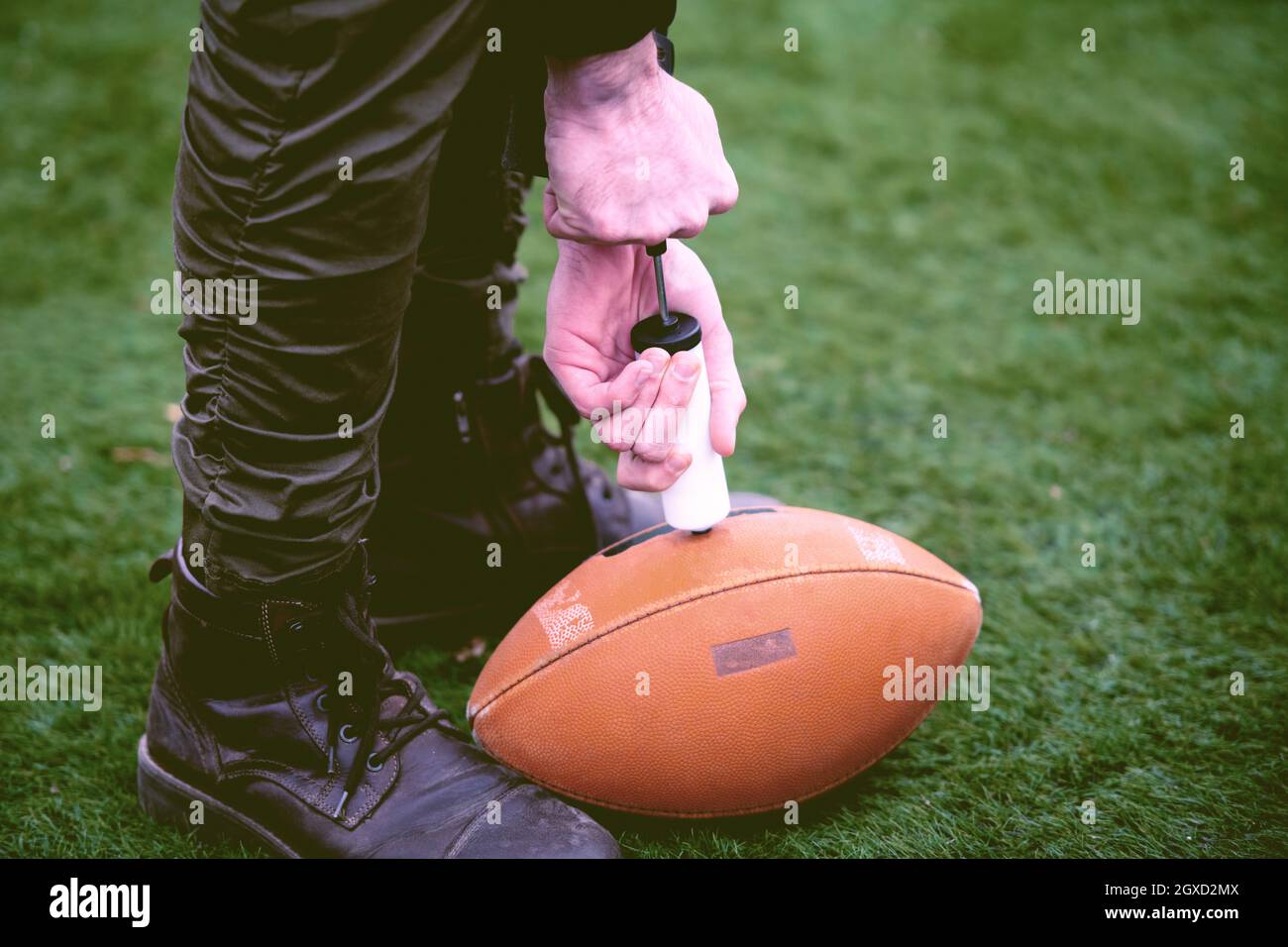 Nahaufnahme der Mann auf dem Feld pumpt Luft in eine Professionelle ball für American Football Stockfoto
