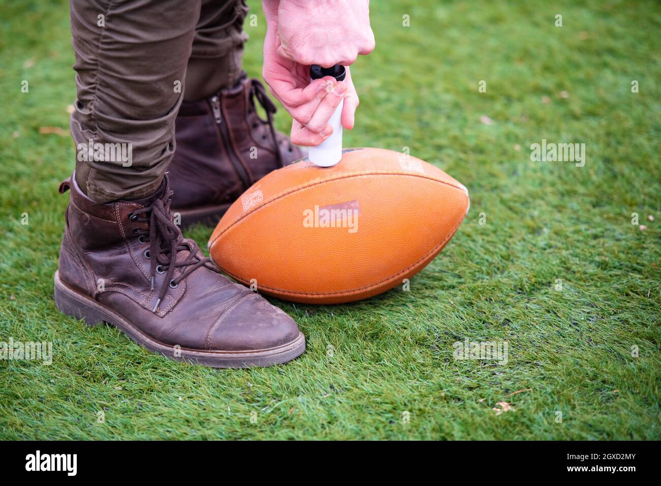 Nahaufnahme der Mann auf dem Feld pumpt Luft in eine Professionelle ball für American Football Stockfoto