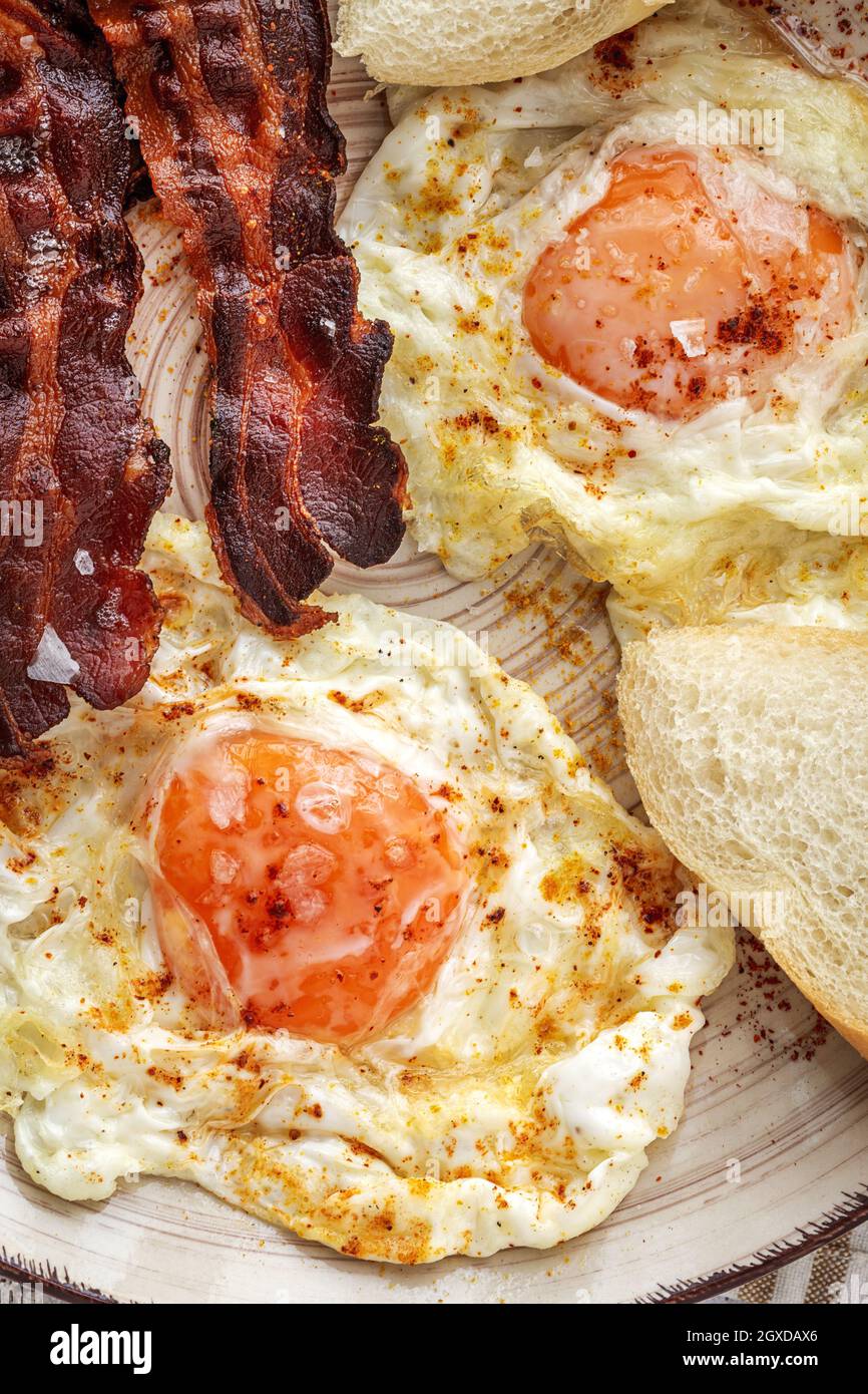 Leckere, sonnige Eier mit gebratenem Speck auf dem Teller Stockfoto