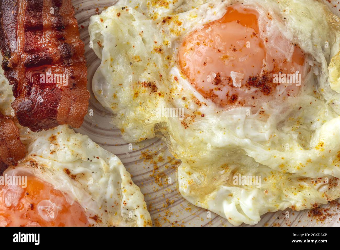 Leckere, sonnige Eier mit gebratenem Speck auf dem Teller Stockfoto