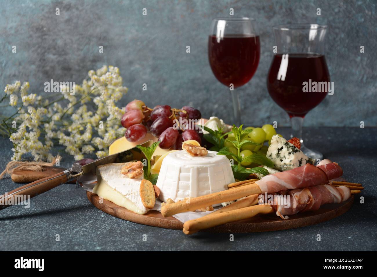 Vorspeisen Tisch mit Snacks. Antipasto Käseplatte, Salami und Prosciutto crudo mit Grissini Brotstäbchen mit Gläsern Wein serviert. Traditionell Stockfoto