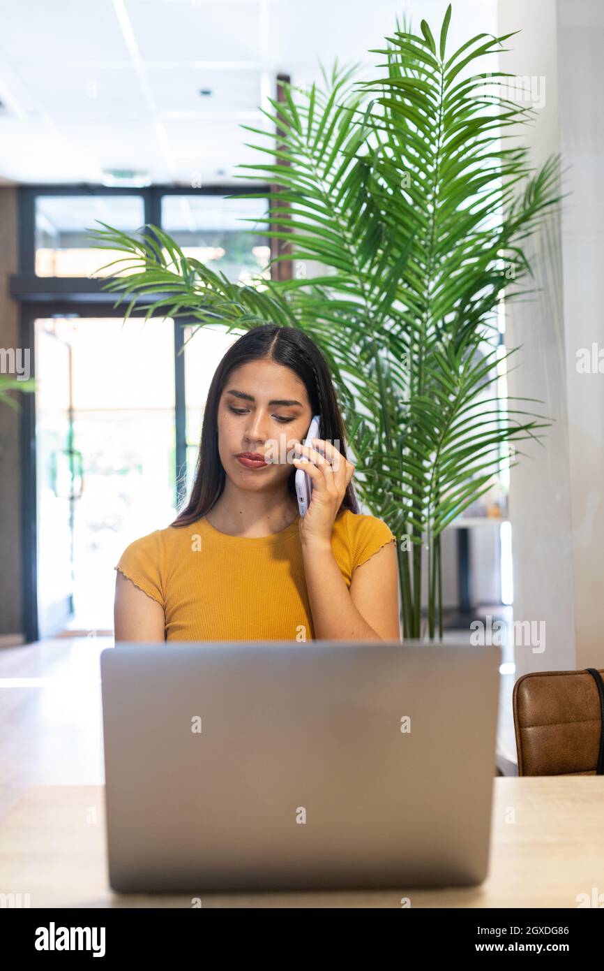 Ansicht von oben von Millennial weiblich mit professioneller Fotokamera liegend Auf zerknittert Textil und Blick auf die Kamera zu Hause Stockfoto