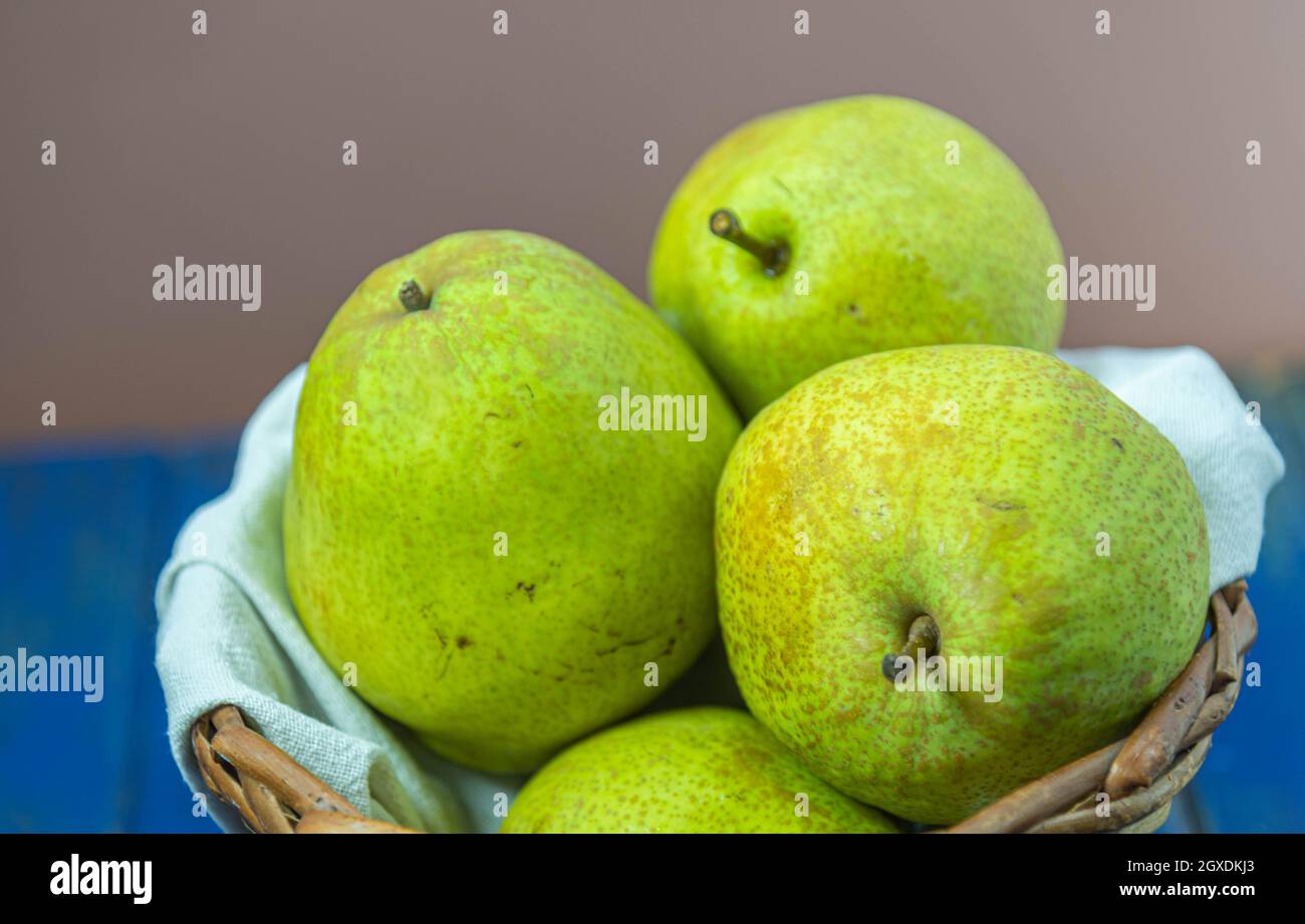 Grüne Birnenfrüchte im Holzkorb auf neutralem Hintergrund. Früchte reich an  Vitamin A, Kalzium und Vitamin C. kalorienarme Lebensmittel. Infredient für  Säfte und Stockfotografie - Alamy