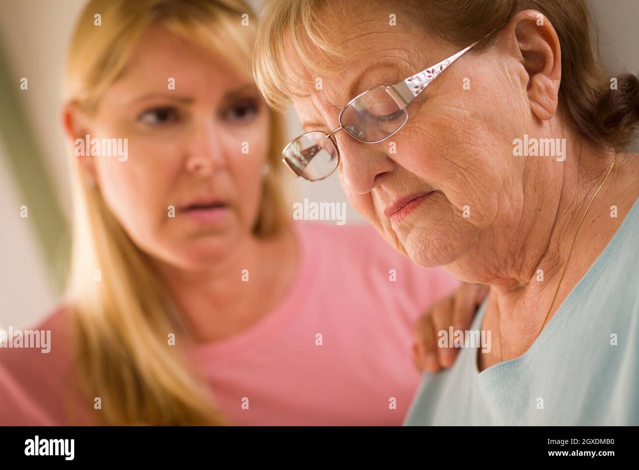Junge Frau tröstet traurige Senior Erwachsenfrau. Stockfoto