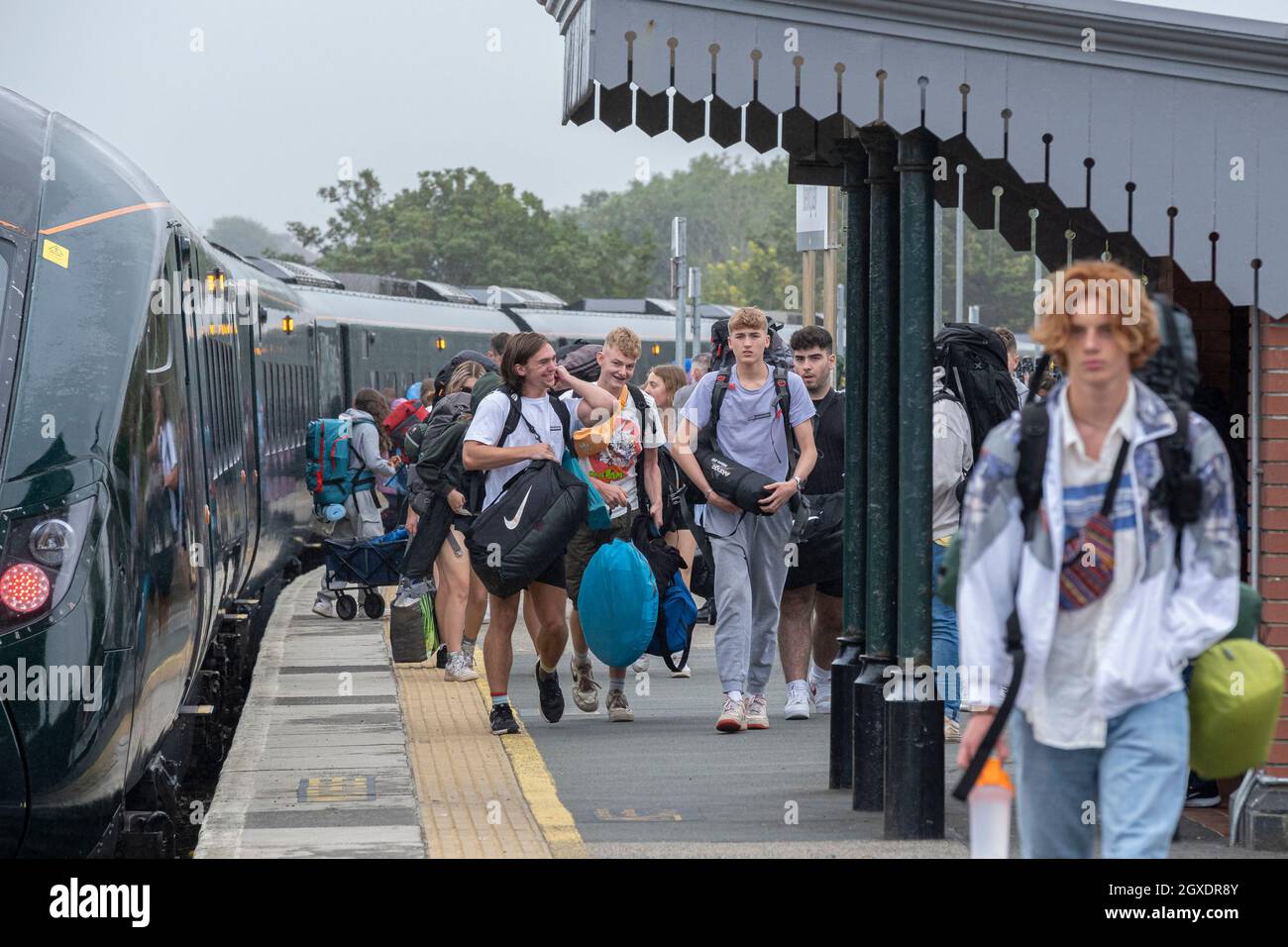 Jugendliche, die am Bahnhof von Newquay zum Eröffnungstag des Boardmasters-Festivals in Cornwall ankommen. Stockfoto