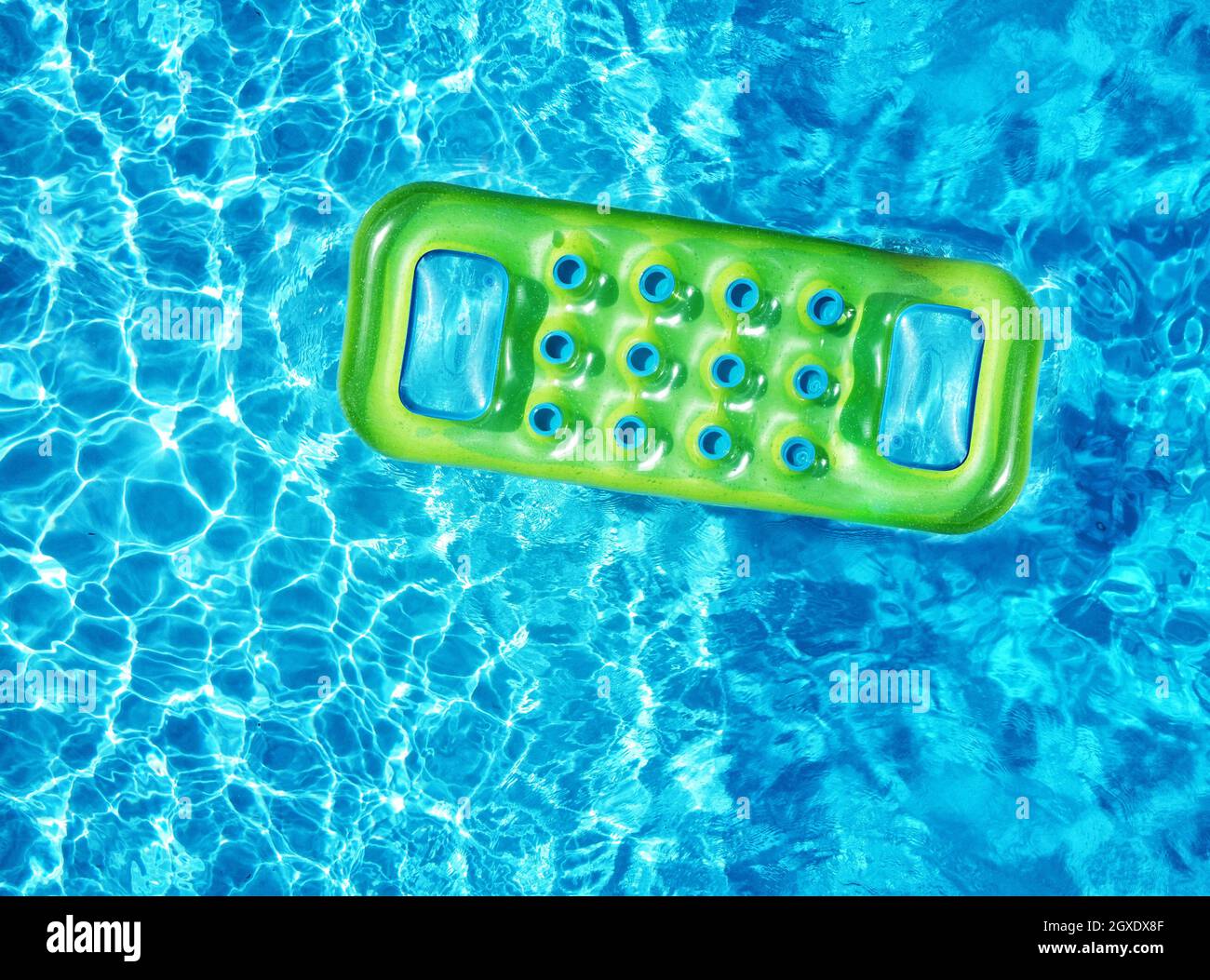 Von oben Drone Blick auf leuchtend grüne aufblasbare Matratze schwimmt auf blauen Wasseroberfläche des Schwimmbades in Sonnenlicht im Sommer Stockfoto