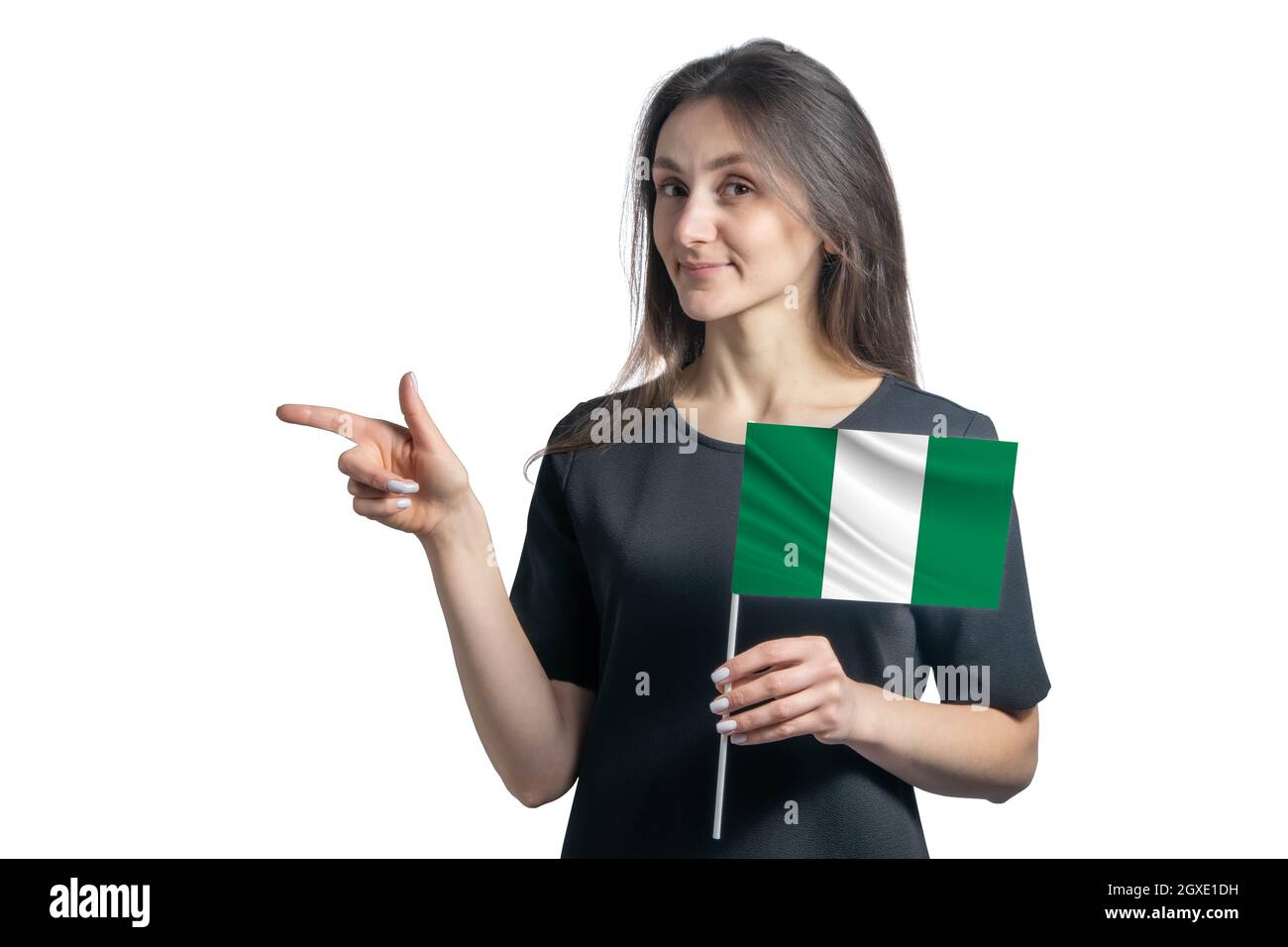 Glückliche junge weiße Frau mit der Flagge Nigeria und zeigt isoliert auf weißem Hintergrund nach links. Stockfoto