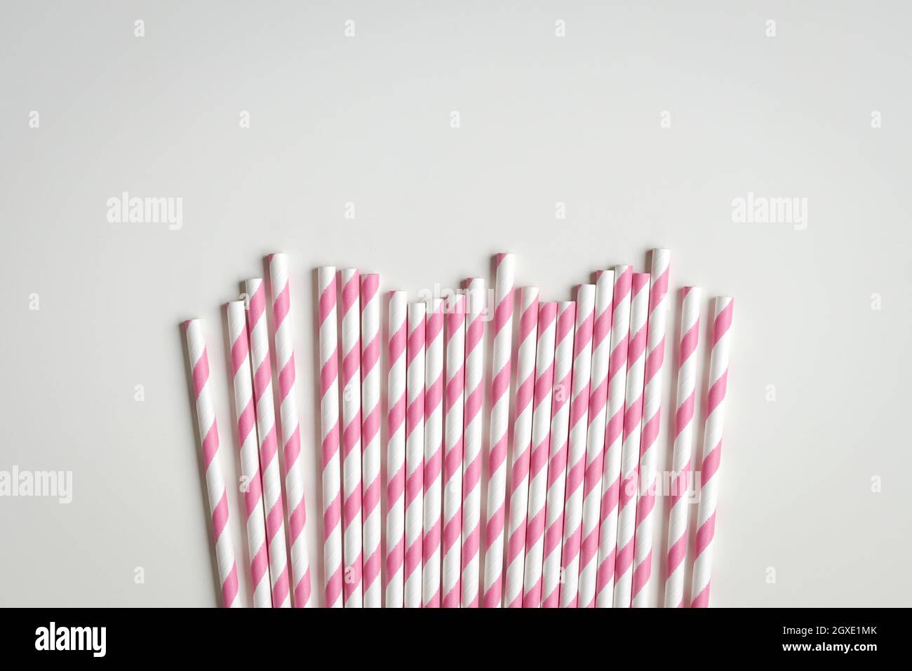 Pinkfarbene Papierhalme auf weißem Hintergrund. Speicherplatz kopieren. Stockfoto