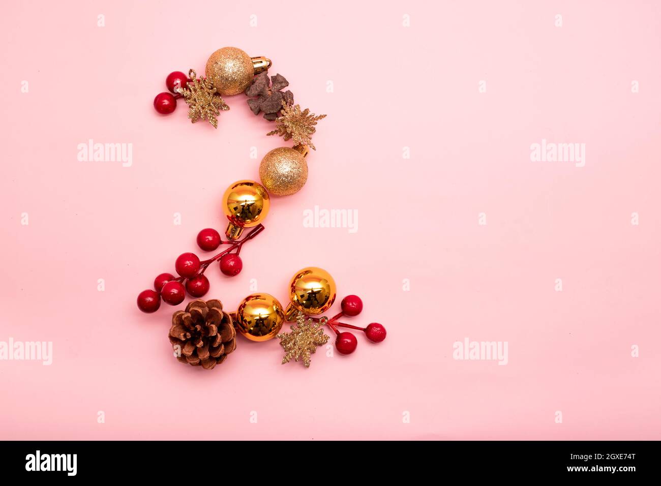 Nummer 2 mit Weihnachtsschmuck auf rosa Hintergrund Stockfoto