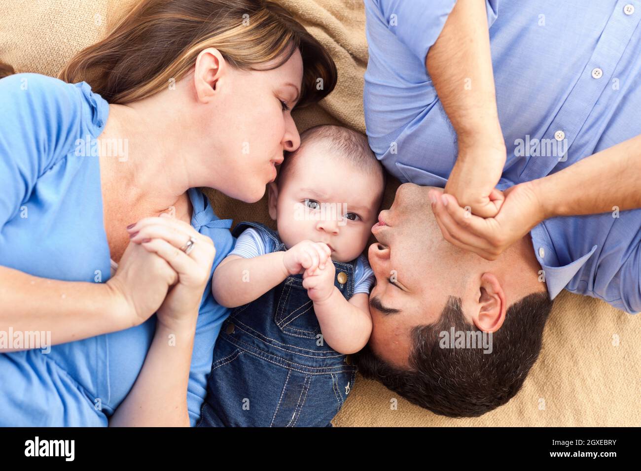 Mixed Race Family mit Baby, das offen auf der Decke spielt Stockfoto