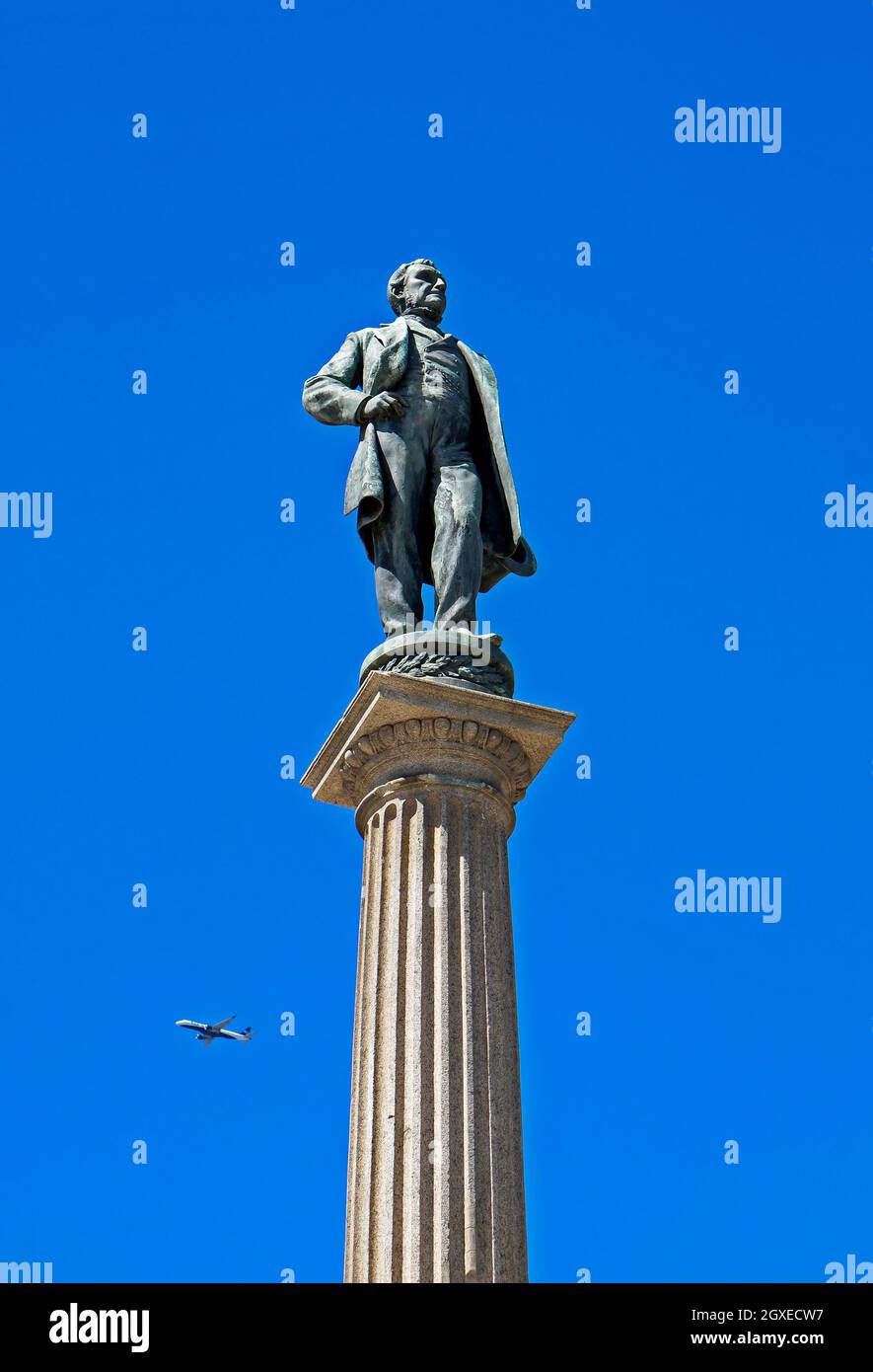 RIO DE JANEIRO, BRASILIEN - 30. DEZEMBER 2019: Statue des Maua Baron (Barao de Maua), auf dem Maua-Platz. Im Hintergrund ein fliegendes Flugzeug Stockfoto