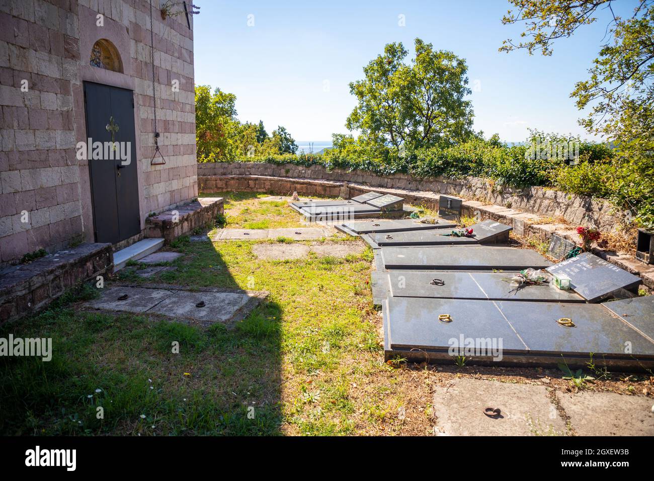 Podostrog, Budva - 23. September 2021: Kirche des heiligen Johannes des Theologen und Friedhof in der Nähe, Podostrog, Budva, Montenegro Stockfoto