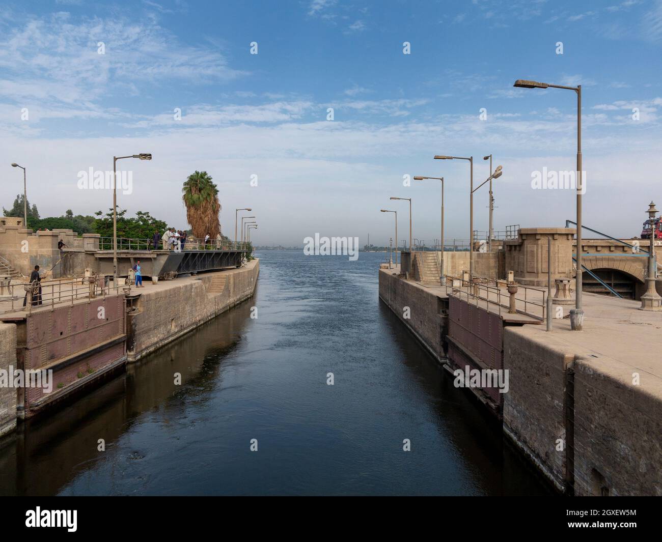 Eine offene Schleuse auf dem Nil, wo Arbeiter herumstanden und auf das Durchkommen des Schiffes warteten Stockfoto