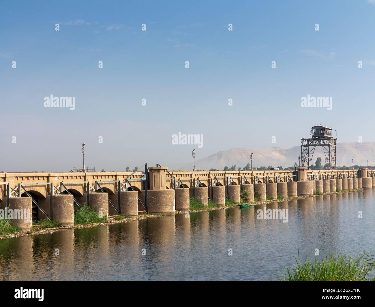 Der Nil im Vordergrund mit Esna-Staudamm am Horizont mit entferntem Wüstengebirge dahinter, Ägypten, Afrika Stockfoto