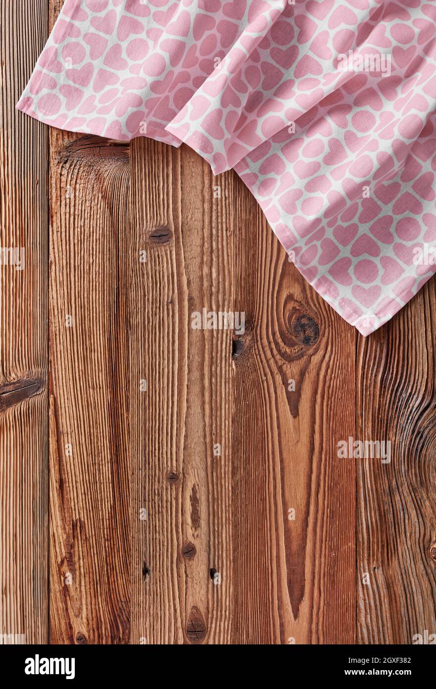 Rosafarbenes Tischtuch in Form eines Herdes auf einem Holztisch Stockfoto