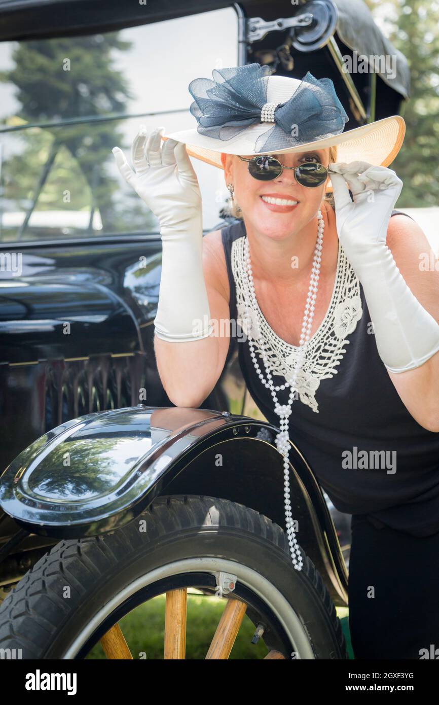 Attraktive Frau in zwanziger Jahre Outfit in der Nähe von antiken Automobile Stockfoto