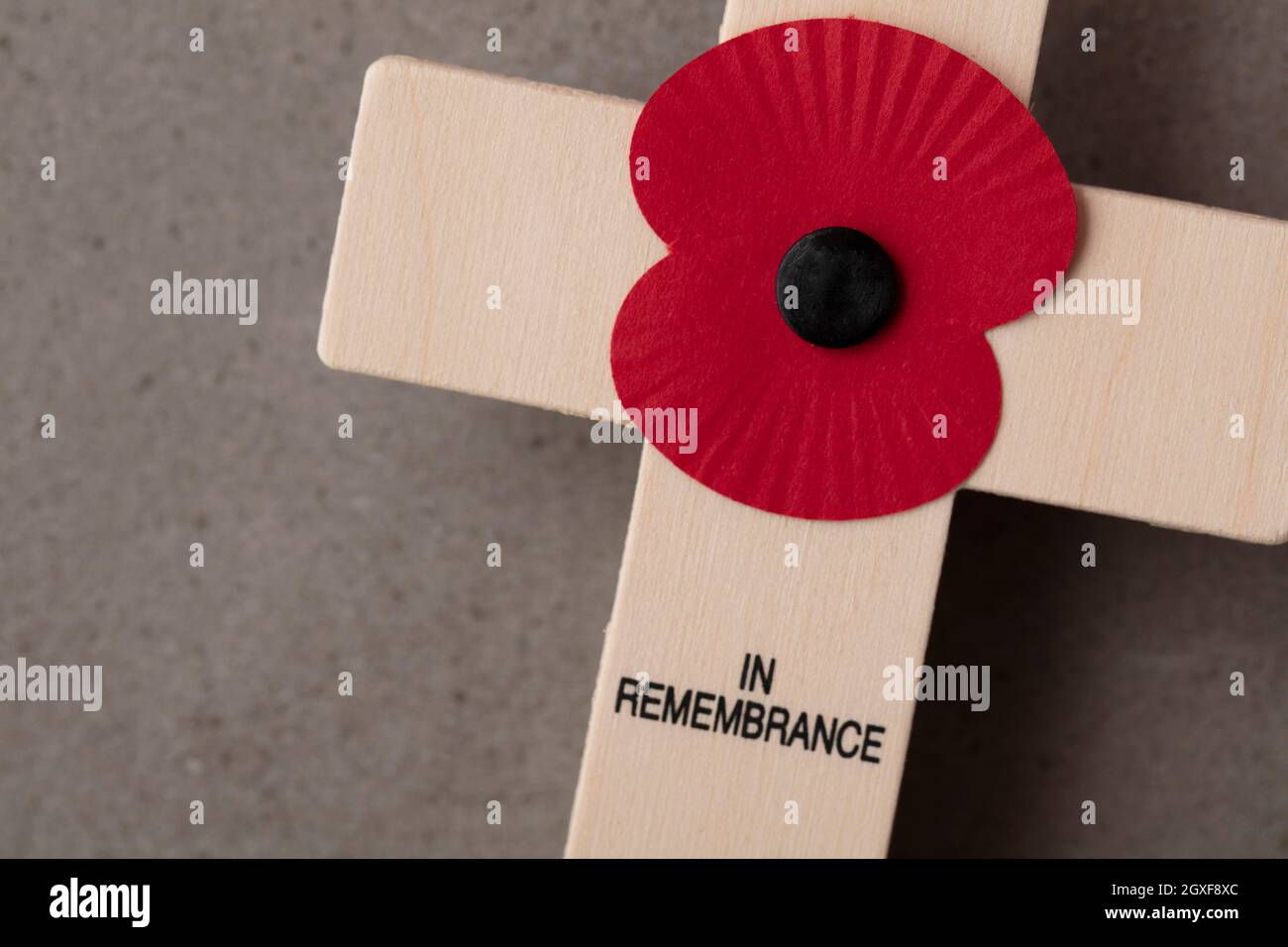 Ein roter Erinnerungsmohn auf einem Holzkreuz. Konzept des militärischen Gedenktages Stockfoto