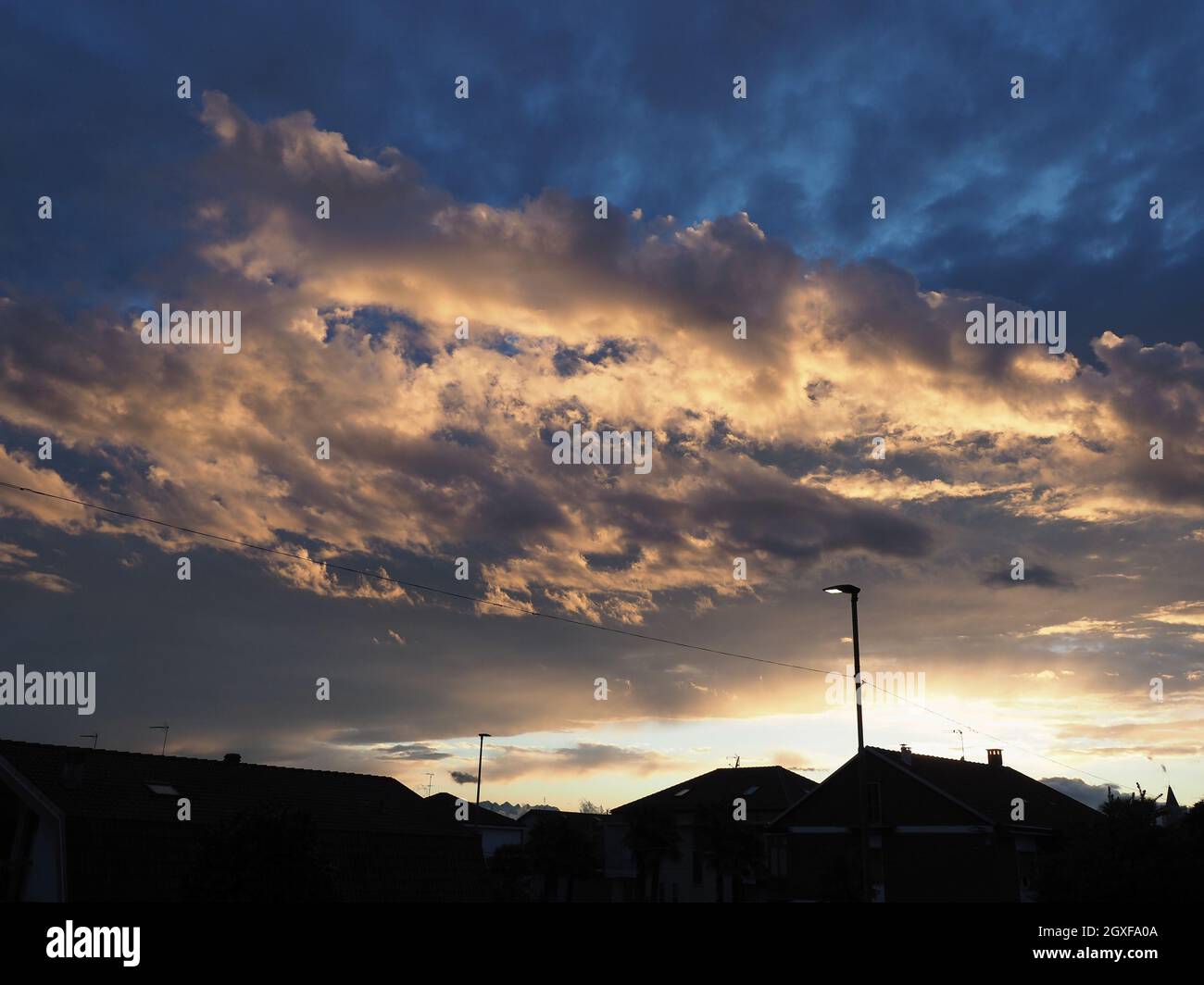 Dramatischer stürmischer blauer Himmel mit dunklen Wolken und städtischer Skyline Silhouette Stockfoto