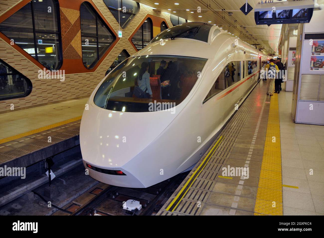 Der Expresszug kommt an einem Bahnsteig in einem Bahnhof in Japan an Stockfoto