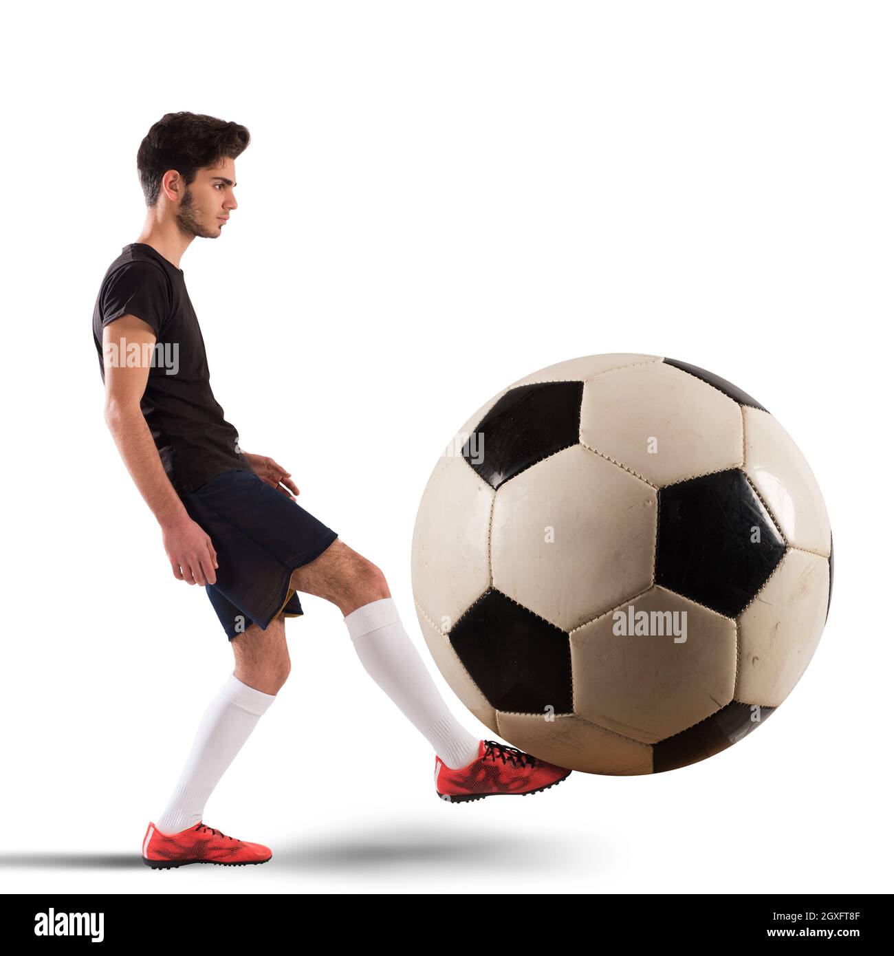 Teenager-Fußballspieler spielt mit großem Soccerball Stockfoto