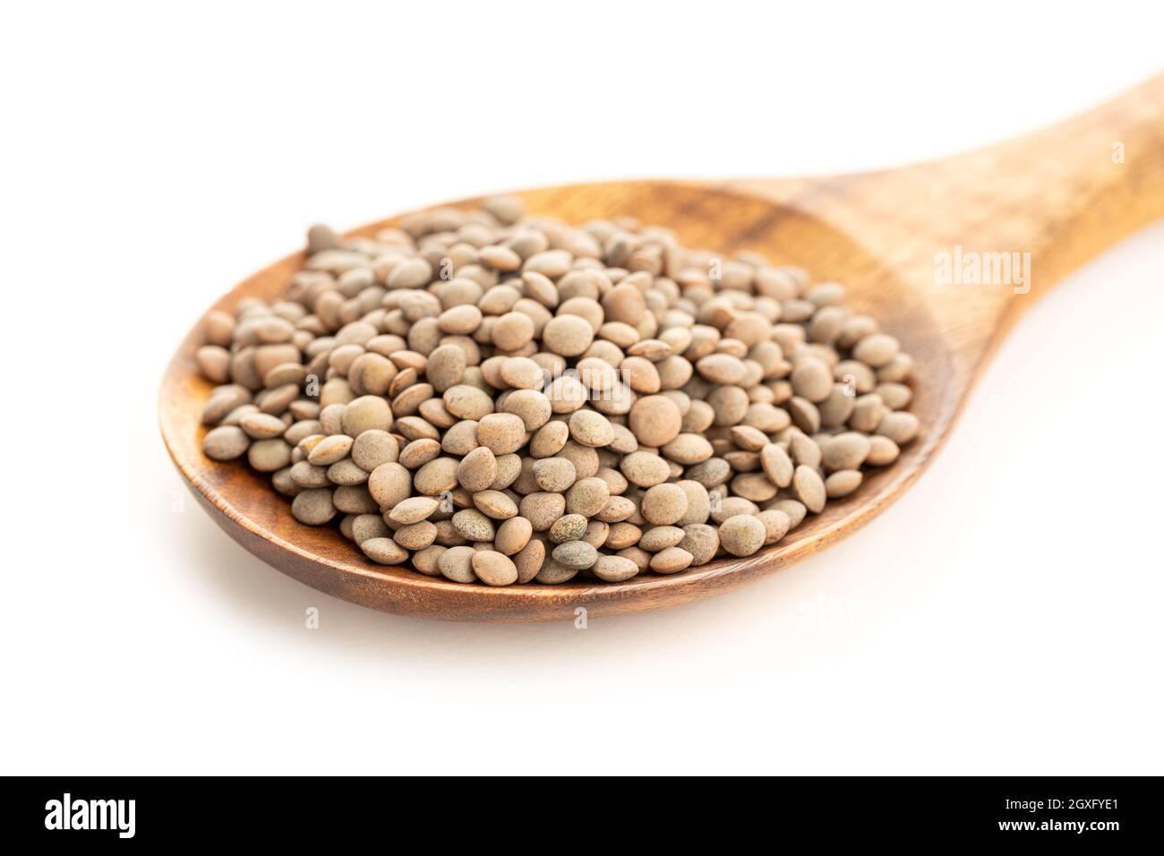 Linsen auf Holzlöffel auf weißem Hintergrund. Linsenculinaris Stockfoto