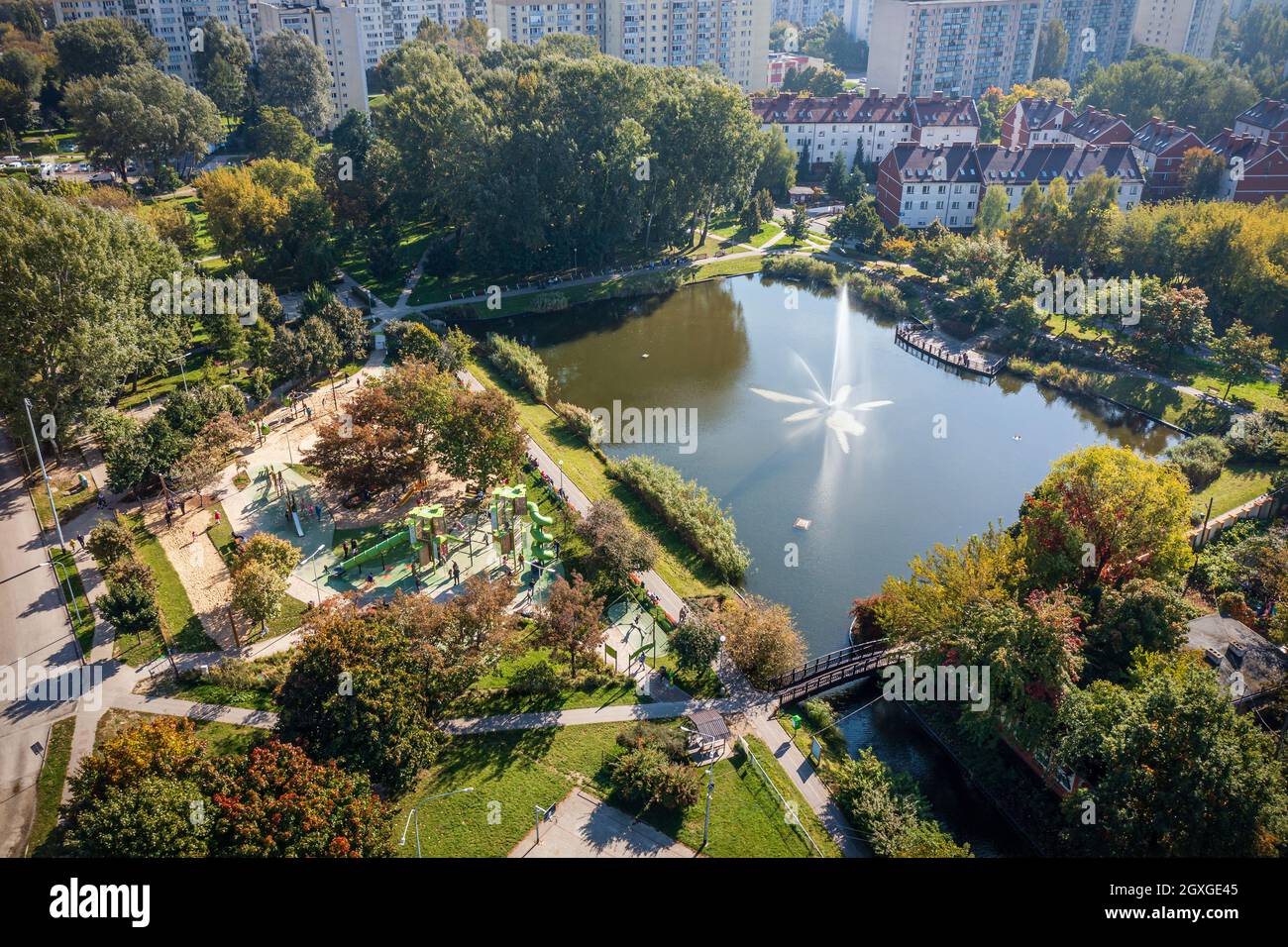 Idyllische Gegend in der Stadt, ein Ort zum Abhängen: Teich mit Brunnen am modernen Spielplatz Stockfoto