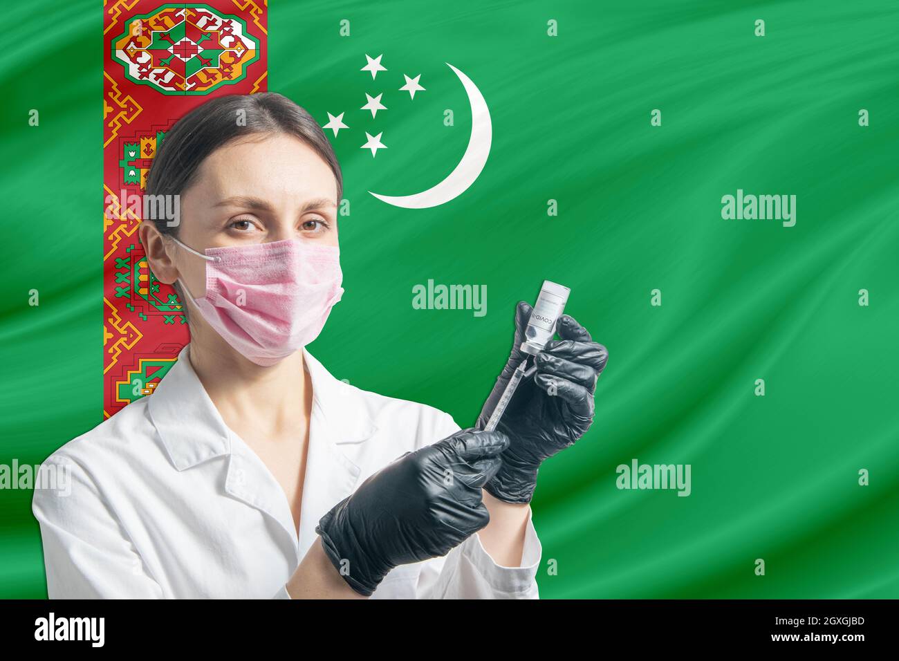 Die Ärztin bereitet die Impfung vor dem Hintergrund der Turkmenistan-Flagge vor. Impfung in Turkmenistan. Stockfoto
