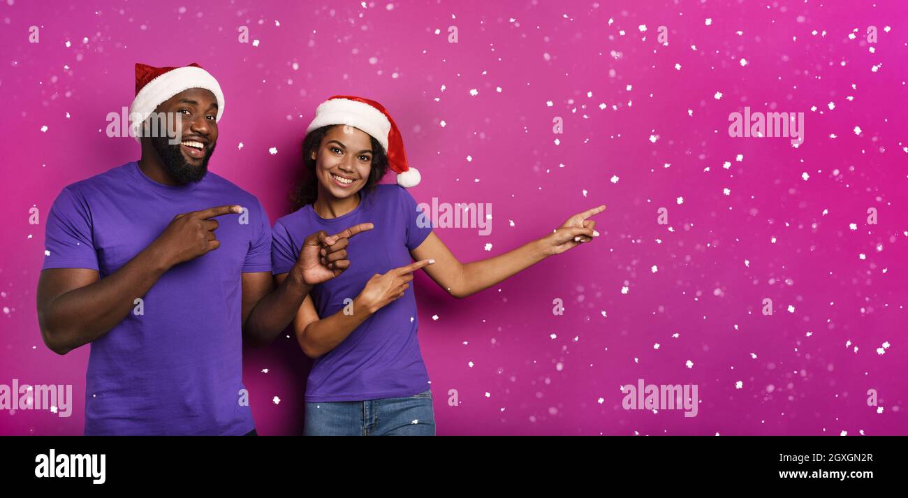 Verblüffte Freunde überrascht von der Ankunft von Weihnachten mit Hut. Violetter Hintergrund Stockfoto