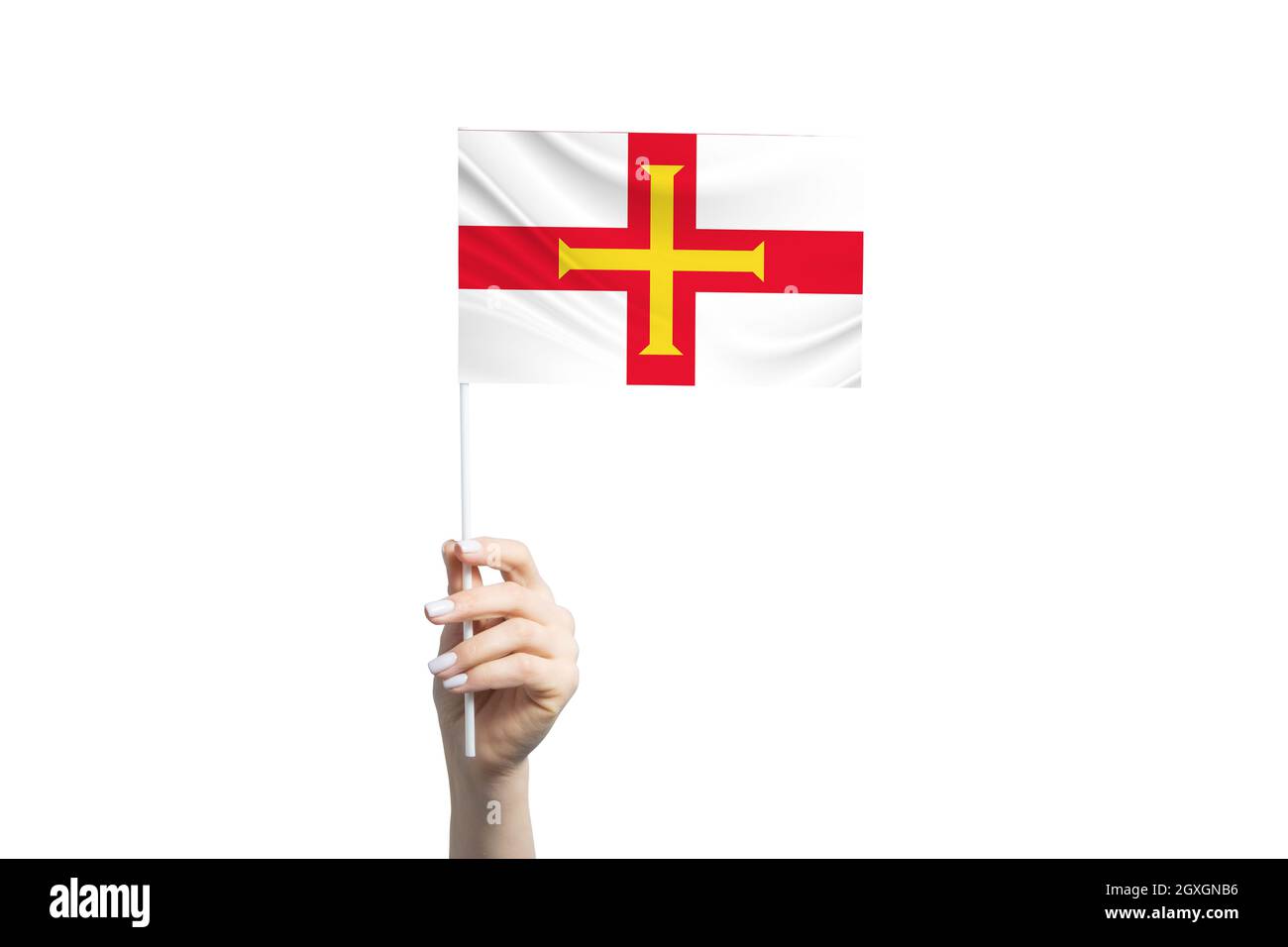 Schöne weibliche Hand hält Guernsey Flagge, isoliert auf weißem Hintergrund. Stockfoto