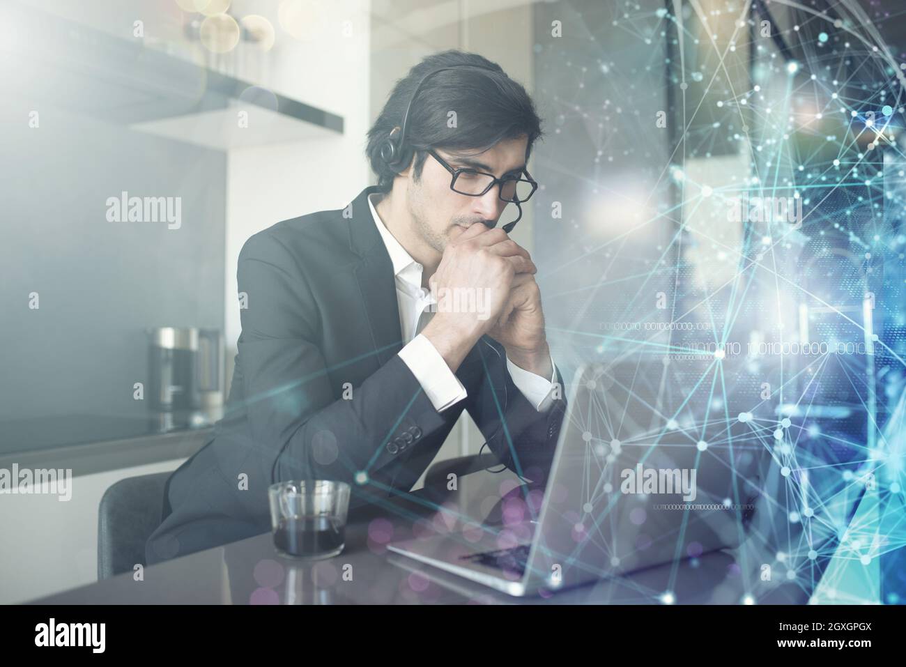 Ein Geschäftsmann mit Headset arbeitet von zu Hause aus mit seinen Kollegen zusammen Stockfoto