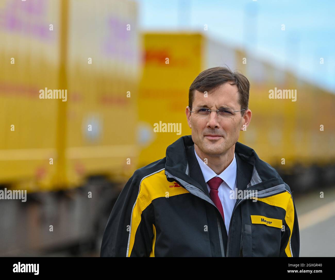 04. Oktober 2021, Brandenburg, Großbeeren: Tobias Meyer, Mitglied des Vorstands für Post und Paket Deutschland, steht am DUSS-Terminal für den Start neuer Verbindungen, damit noch mehr DHL-Pakete klimafreundlich per Bahn transportiert werden können. Der Logistikkonzern Deutsche Post DHL Group und die Deutsche Bahn AG bauen ihre bestehende Zusammenarbeit im Bereich des Paketverkehrs auf der Schiene aus. Ziel ist es, den Anteil der per Bahn transportierten DHL-Pakete von 2 auf 6 Prozent zu erhöhen. Neue Strecken sollen auch dem bestehenden Schienennetz für Pakete hinzugefügt werden. Foto: Pat Stockfoto