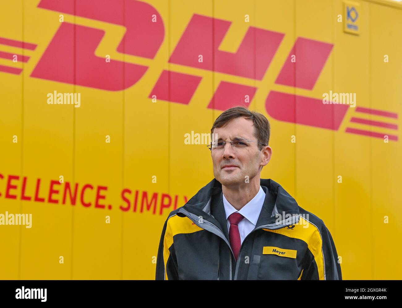 04. Oktober 2021, Brandenburg, Großbeeren: Tobias Meyer, Mitglied des Vorstands für Post und Paket Deutschland, steht am DUSS-Terminal für den Start neuer Verbindungen, damit noch mehr DHL-Pakete klimafreundlich per Bahn transportiert werden können. Der Logistikkonzern Deutsche Post DHL Group und die Deutsche Bahn AG bauen ihre bestehende Zusammenarbeit im Bereich des Paketverkehrs auf der Schiene aus. Ziel ist es, den Anteil der per Bahn transportierten DHL-Pakete von 2 auf 6 Prozent zu erhöhen. Neue Strecken sollen auch dem bestehenden Schienennetz für Pakete hinzugefügt werden. Foto: Pat Stockfoto