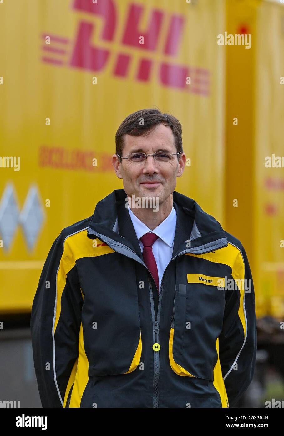 04. Oktober 2021, Brandenburg, Großbeeren: Tobias Meyer, Mitglied des Vorstands für Post und Paket Deutschland, steht am DUSS-Terminal für den Start neuer Verbindungen, damit noch mehr DHL-Pakete klimafreundlich per Bahn transportiert werden können. Der Logistikkonzern Deutsche Post DHL Group und die Deutsche Bahn AG bauen ihre bestehende Zusammenarbeit im Bereich des Paketverkehrs auf der Schiene aus. Ziel ist es, den Anteil der per Bahn transportierten DHL-Pakete von 2 auf 6 Prozent zu erhöhen. Neue Strecken sollen auch dem bestehenden Schienennetz für Pakete hinzugefügt werden. Foto: Pat Stockfoto