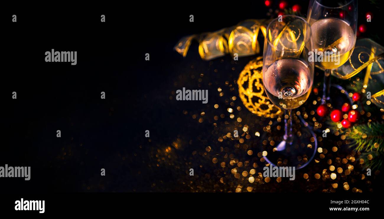 Sektflöten und weihnachtsdekoration mit goldenem Glitzer auf schwarzem Hintergrund. Luxus Urlaub Restaurant Abendessen. Silvesterparty-Banner. Elegant Stockfoto