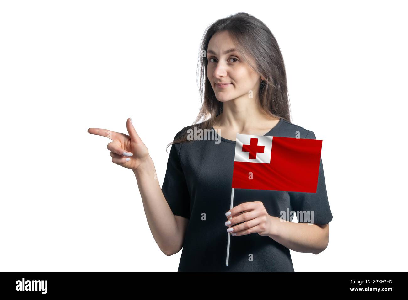 Glückliche junge weiße Frau hält Flagge Tonga und zeigt nach links isoliert auf einem weißen Hintergrund. Stockfoto