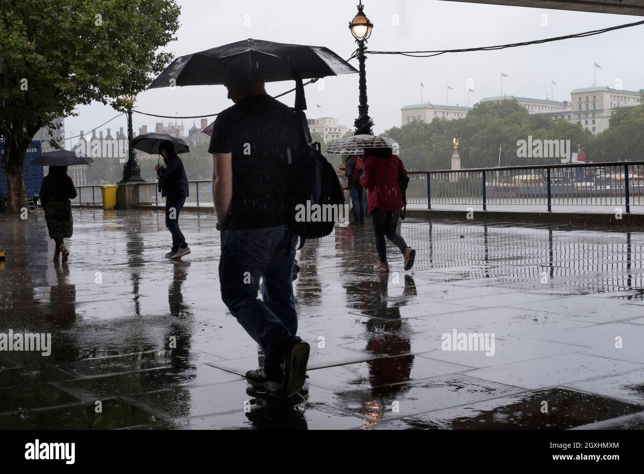 Fußgänger aus London, die im Regenguss laufen. Stockfoto