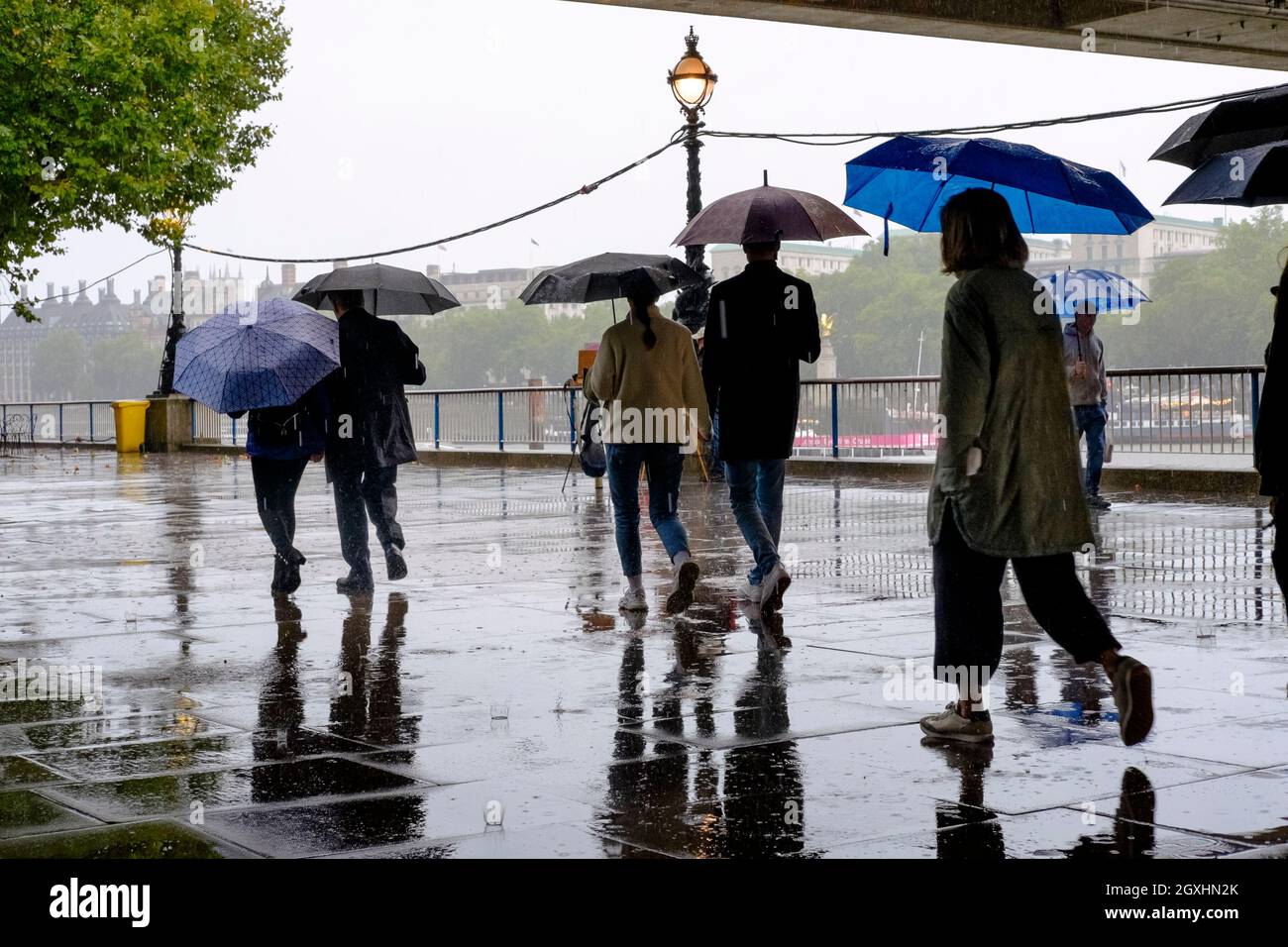 Fußgänger aus London, die im Regenguss laufen. Stockfoto