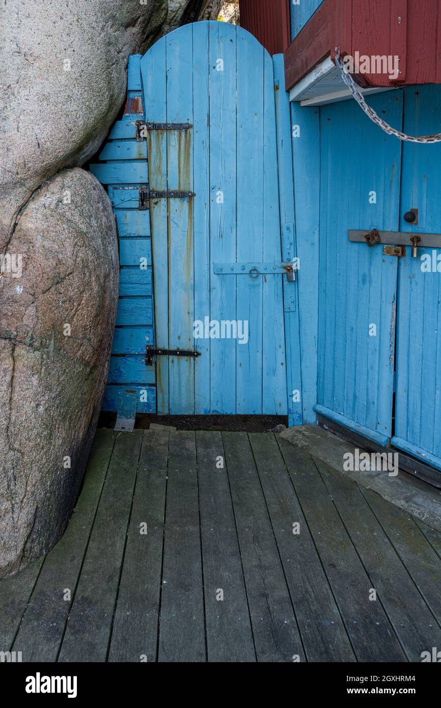 Eine alte blaue Holztür neben einer Felsformation. Bild aus der schwedischen Felseninsel Smogen Stockfoto