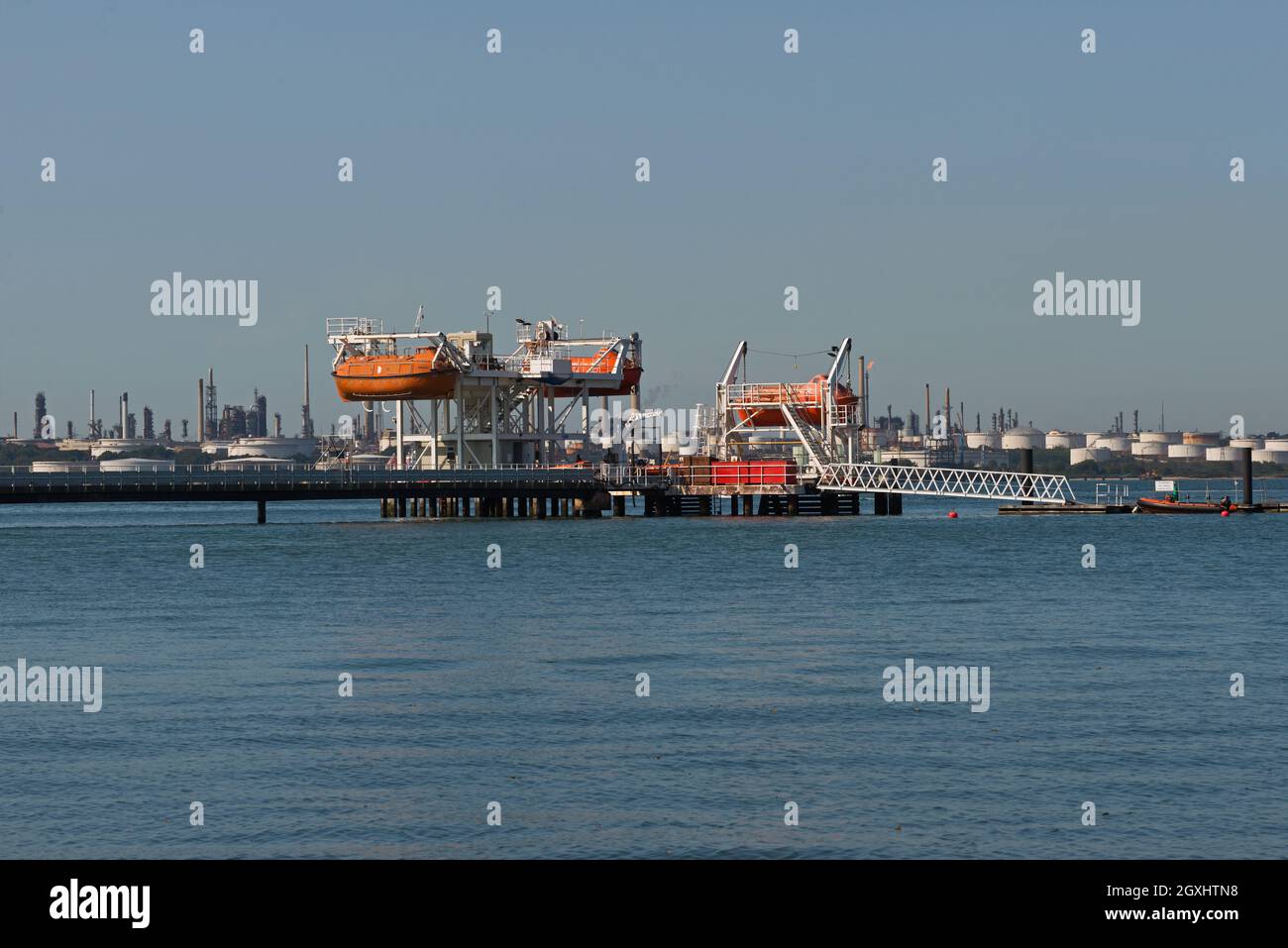 Blick über den Eingang zum River Hamble, vorbei an der Warsash School, dem Academy Pier mit Southampton Water und der Fawley Oil Raffinerie in der Ferne Stockfoto