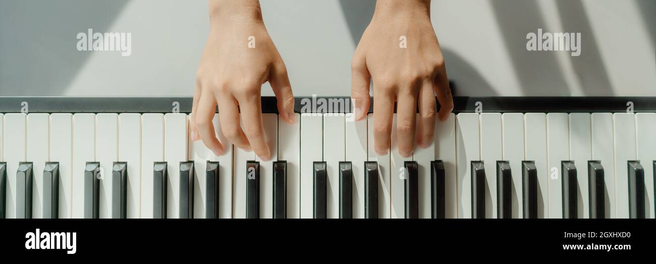 Frau lernt zu Hause Klavier auf digitaler Tastatur zu spielen. Panorama-Banner Ernte der Hände spielen Anfänger Akkorde zu lernen, spielen allein Stockfoto