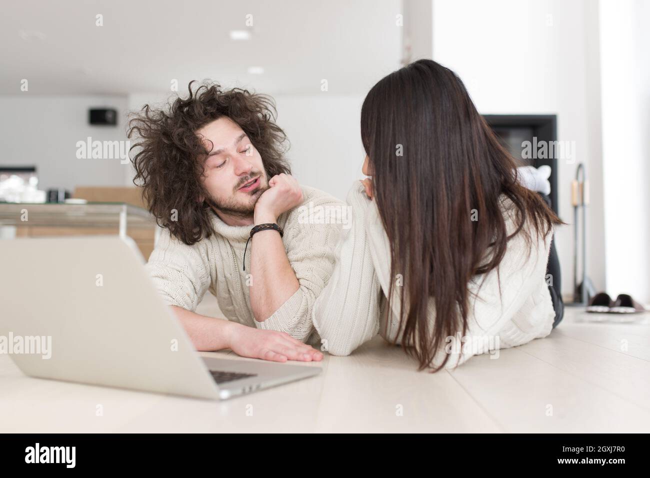 Junge schöne multiethnischen paar mit einem Laptop und Online-shopping zu Hause auf dem Boden Stockfoto